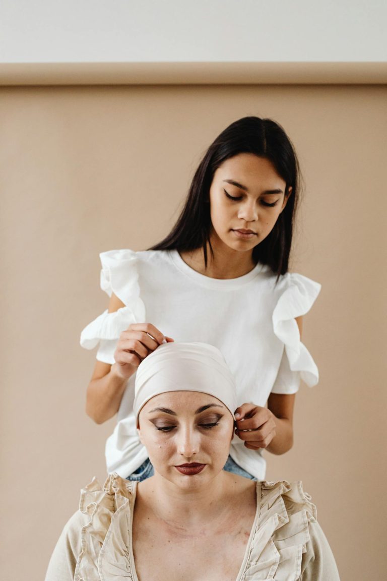 Asian woman supporting cancer patient with headscarf, showing friendship and care.