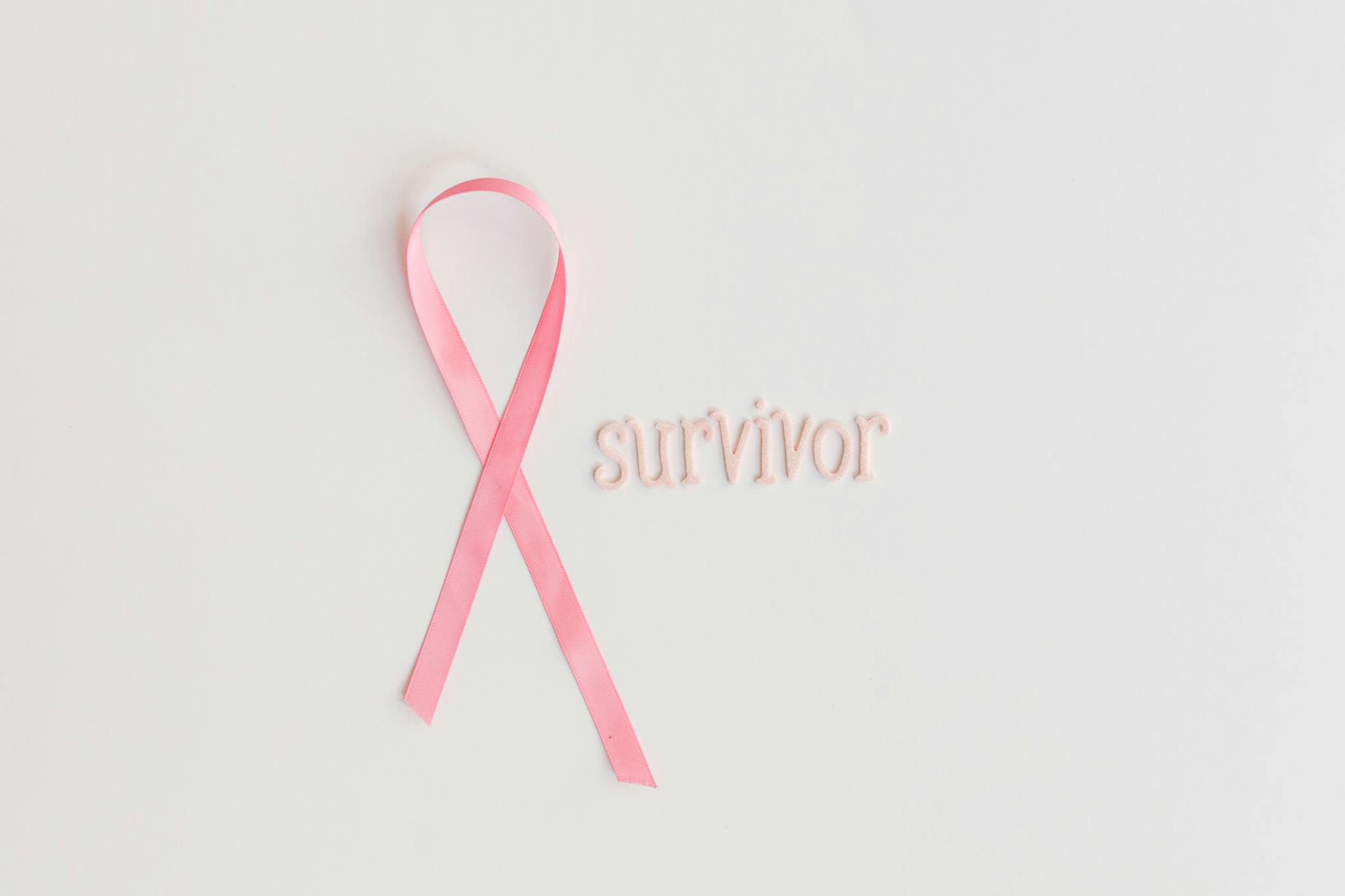 Image of a pink ribbon with 'survivor' text symbolizing breast cancer awareness.