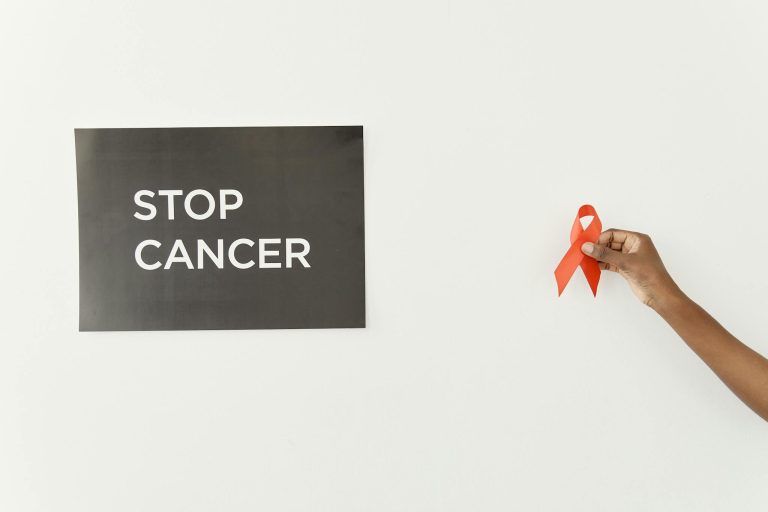 Powerful image advocating cancer awareness featuring a red ribbon and 'Stop Cancer' message.